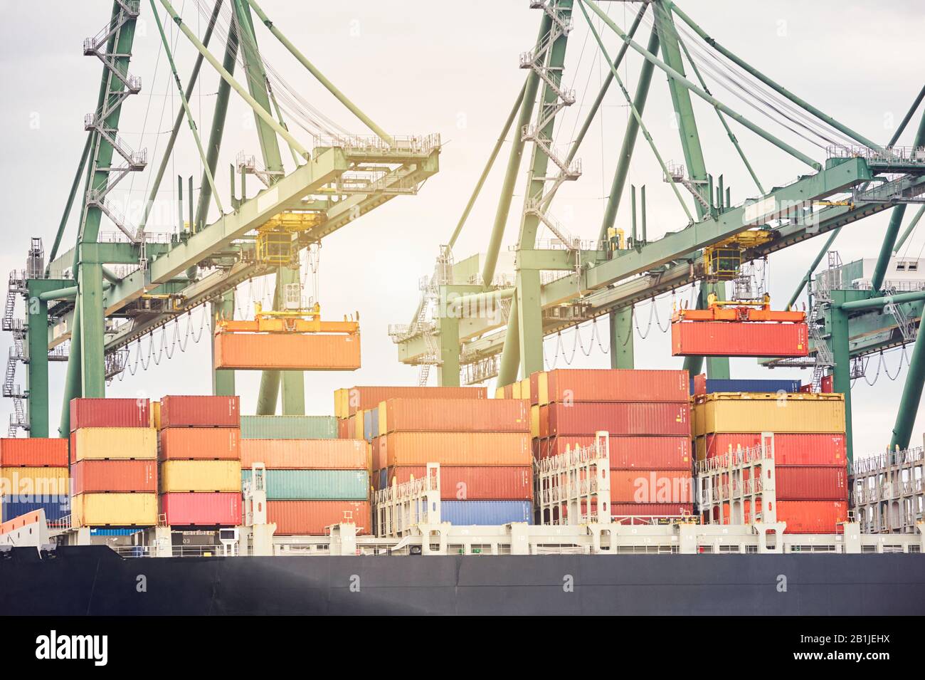 Schiffskran Entladen von Containern von einem Schiff im Hafengebiet. Transportindustrie und Versandlogistik. Exportieren und Importieren von Bussinen Stockfoto