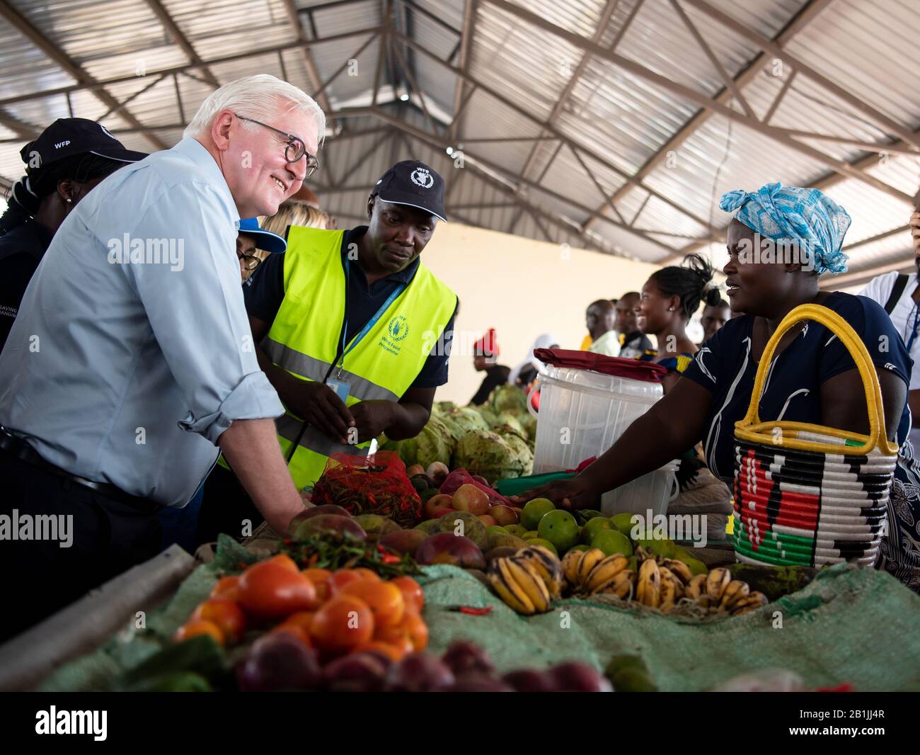 Kakuma, Kenia. Februar 2020. Bundespräsident Frank-Walter Steinmeier (l) besucht den Markt von Kalobeyei bei Kukuma, wo Flüchtlinge ihr selbst angebautes Gemüse verkaufen, und kauft Äpfel. Kakuma ist eines der größten Flüchtlingslager des Landes. Mehr als eine halbe Million Flüchtlinge aus über 30 Ländern leben derzeit in Kenia. Bundespräsident Steinmeier ist auf einem dreitägigen Staatsbesuch in Kenia. Credit: Bernd von Jutrczenka / dpa / Alamy Live News Stockfoto