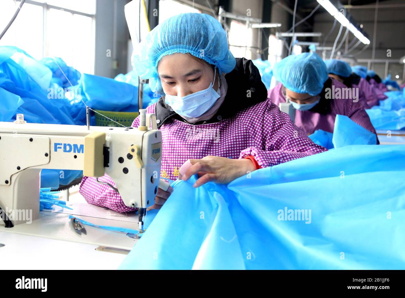 Chinesische Arbeiter nähen und fertigen am 26. Februar 2020 medizinische Schutzkleidung in einer Bekleidungsfabrik in Zaozhuang City, der ostchinesischen Provinz Shandong Stockfoto