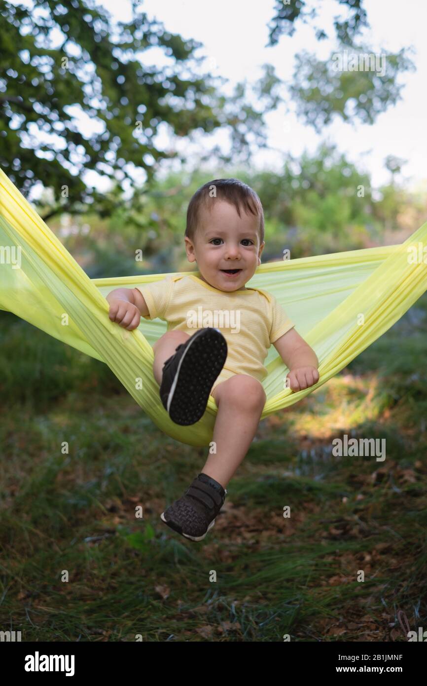 Kleines Kind auf gelber Hängematte im Quellwald. Reisen mit Kinderkonzept Stockfoto