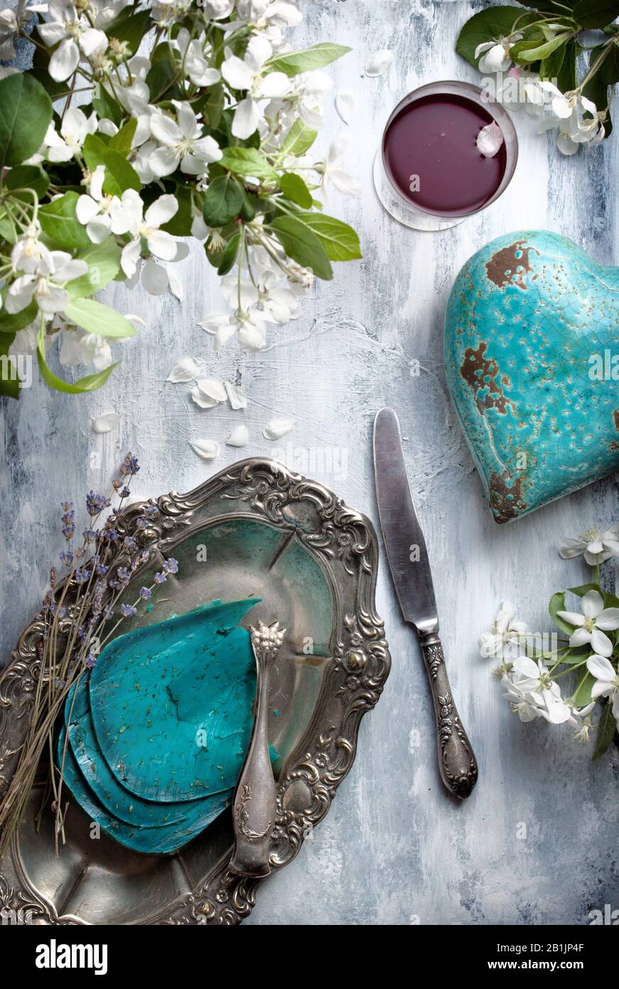 Flatlay essen Hintergrund - leere Holztisch mit Blauschimmelkäse Stücke, weißen Blüten und silber antik Geschirr Stockfoto