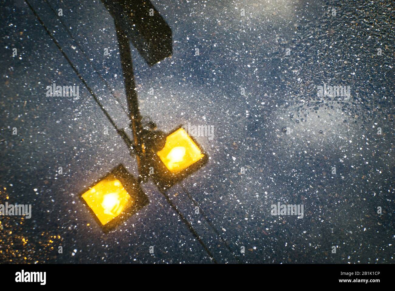 Reflektion der Straßenlampe in der Wasserpfütze, Merlynston Station, Melbourne, Australien. Stockfoto