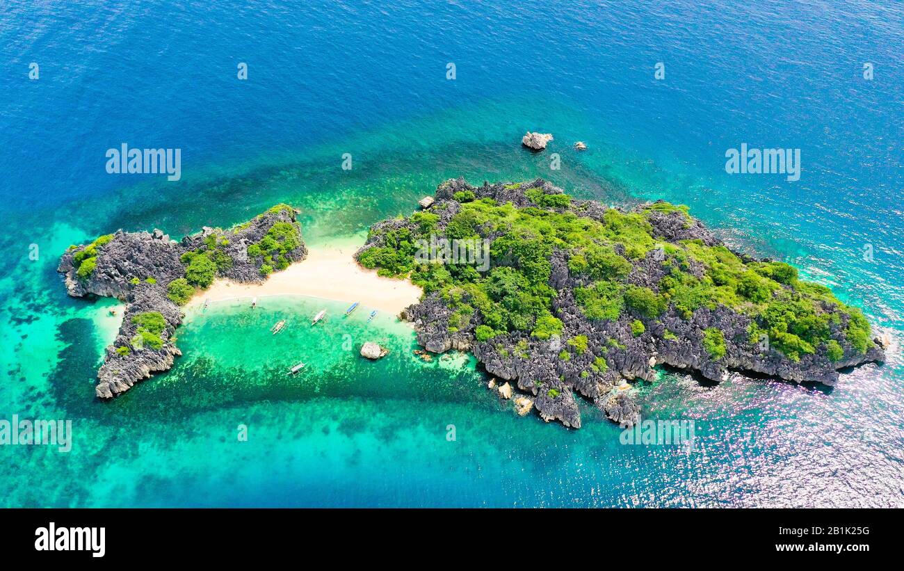 Luftaufnahme von der kleinen, isolierten tropischen Insel mit weißem Sandstrand und blauem, transparentem Wasser und Korallenriffen. Lahos Island, Caramoan-Inseln, Philippinen. Stockfoto