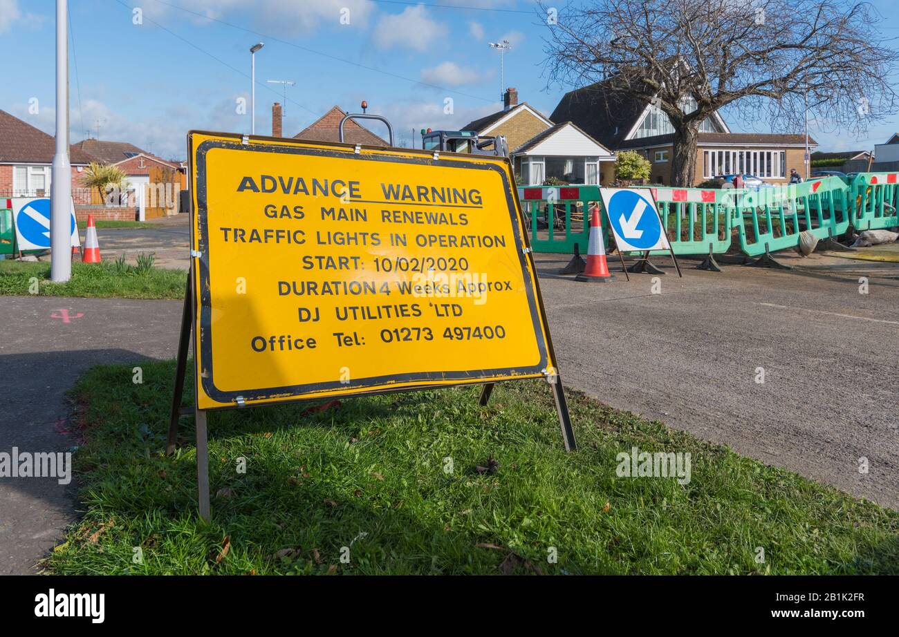 Gelbes Warnschild für Gashauptverlängerungen und Straßenbauarbeiten auf einer Straße in England, Großbritannien. Stockfoto