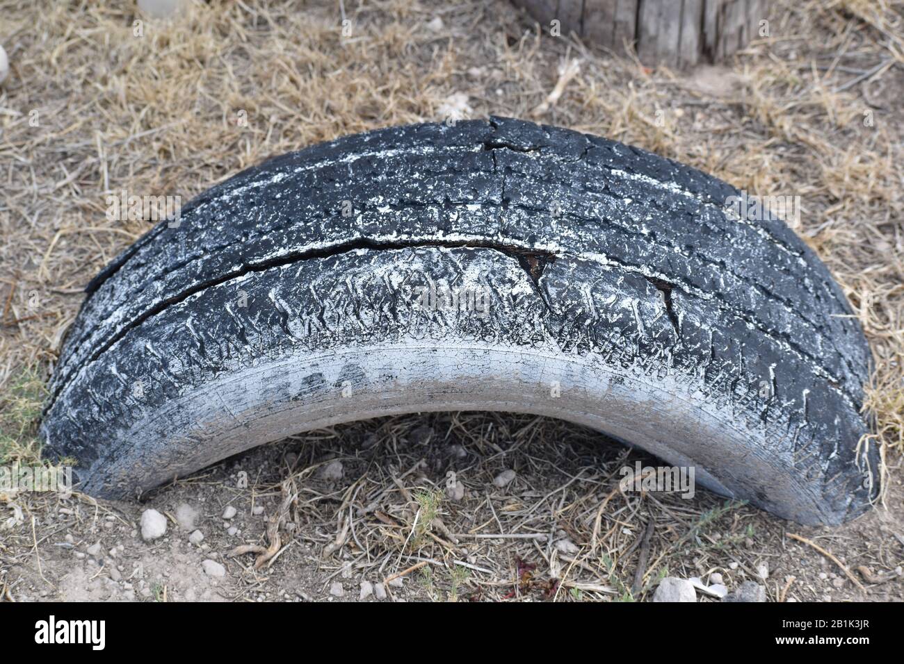 Isolierte Nahaufnahme von gebrauchten Reifen, die im Boden vergraben wurden Stockfoto