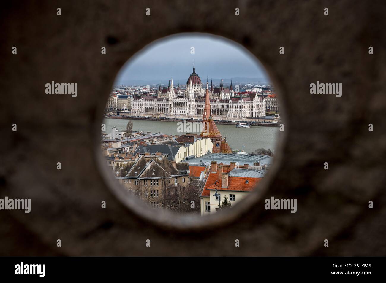 Das ungarische Parlamentsgebäude, das durch ein Loch in der Fischerbastion auf dem Buda-Hügel, Budapest mit, gesehen wird Stockfoto