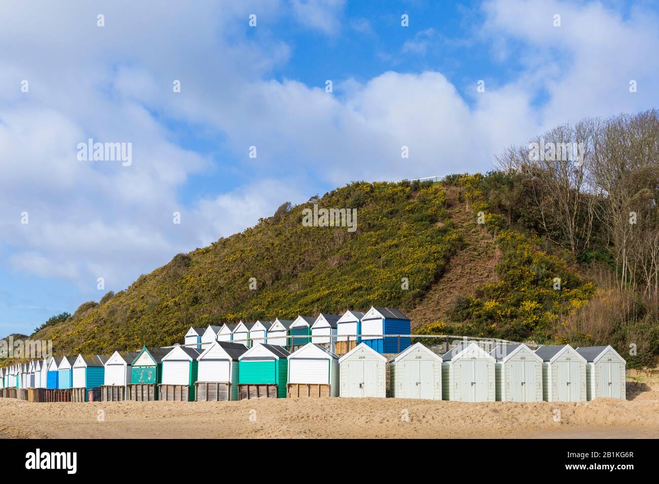 Strandhütten in Middle Chine mit Strandpromenade, die im Sand aus dem jüngsten schlechten Wetter in Bournemouth, Dorset UK, an einem sonnigen kalten Tag im Februar bedeckt ist Stockfoto