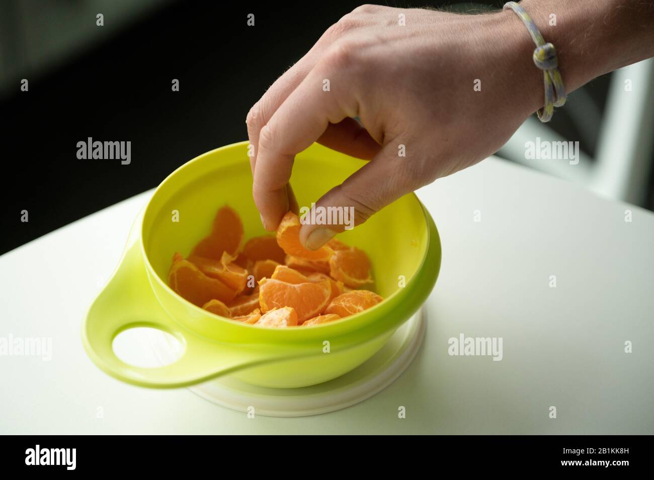 Berlin, Deutschland. Februar 2020. Ein Mann nimmt Mandarinen aus einer  Frischektin der Marke Tupperware. Das Unternehmen Tupperware aus Orlando im  sonnigen Florida befindet sich in einer tiefen Krise. Der zunehmende  Wettbewerb auf