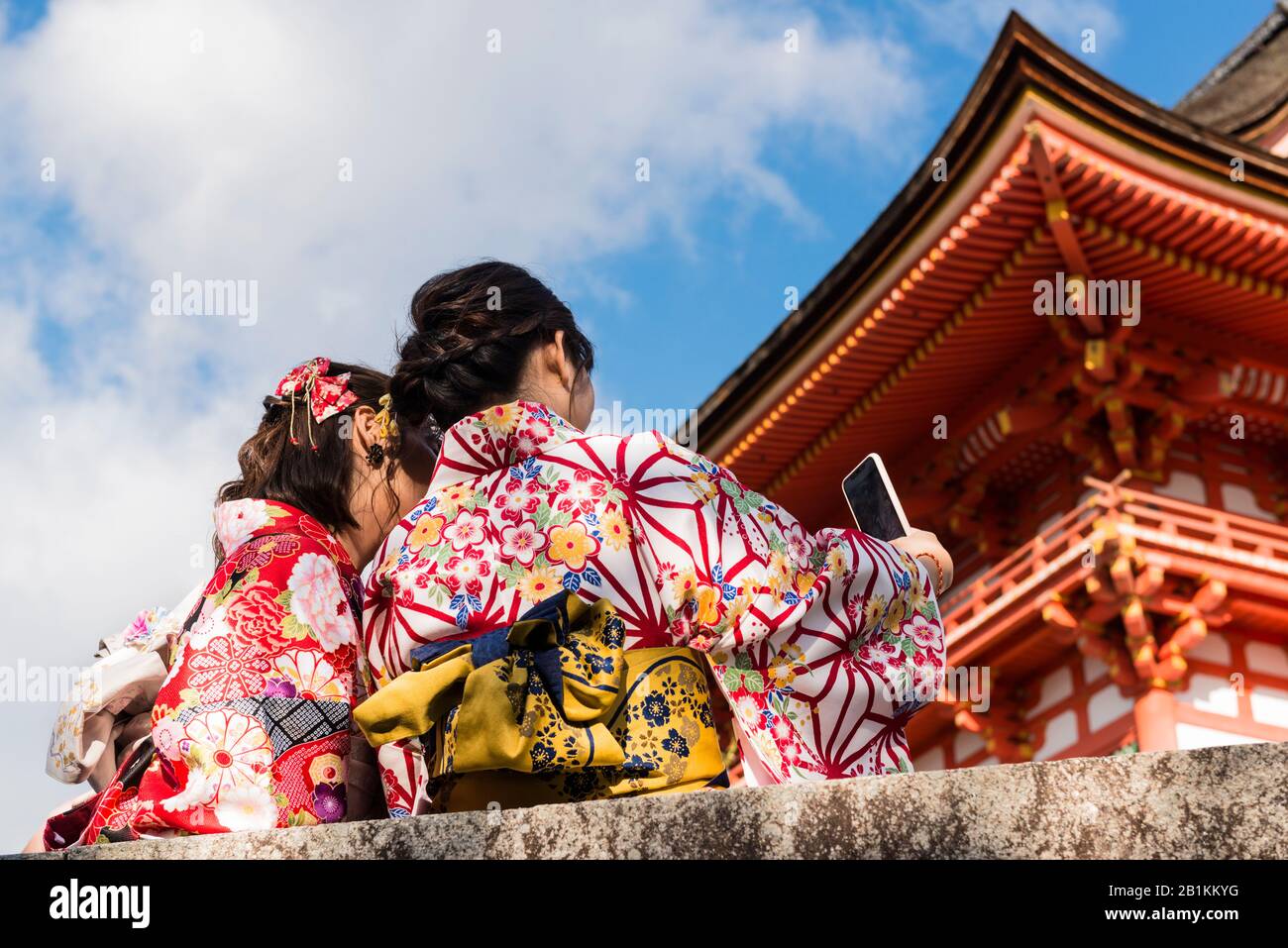 Junge Frauen, die Selfies nehmen, gekleidet in Kimonos, das für den Tag gemietet werden kann, außerhalb von Kiyomizu-dera, einem unabhängigen buddhistischen Tempel im Osten Kyotos Stockfoto