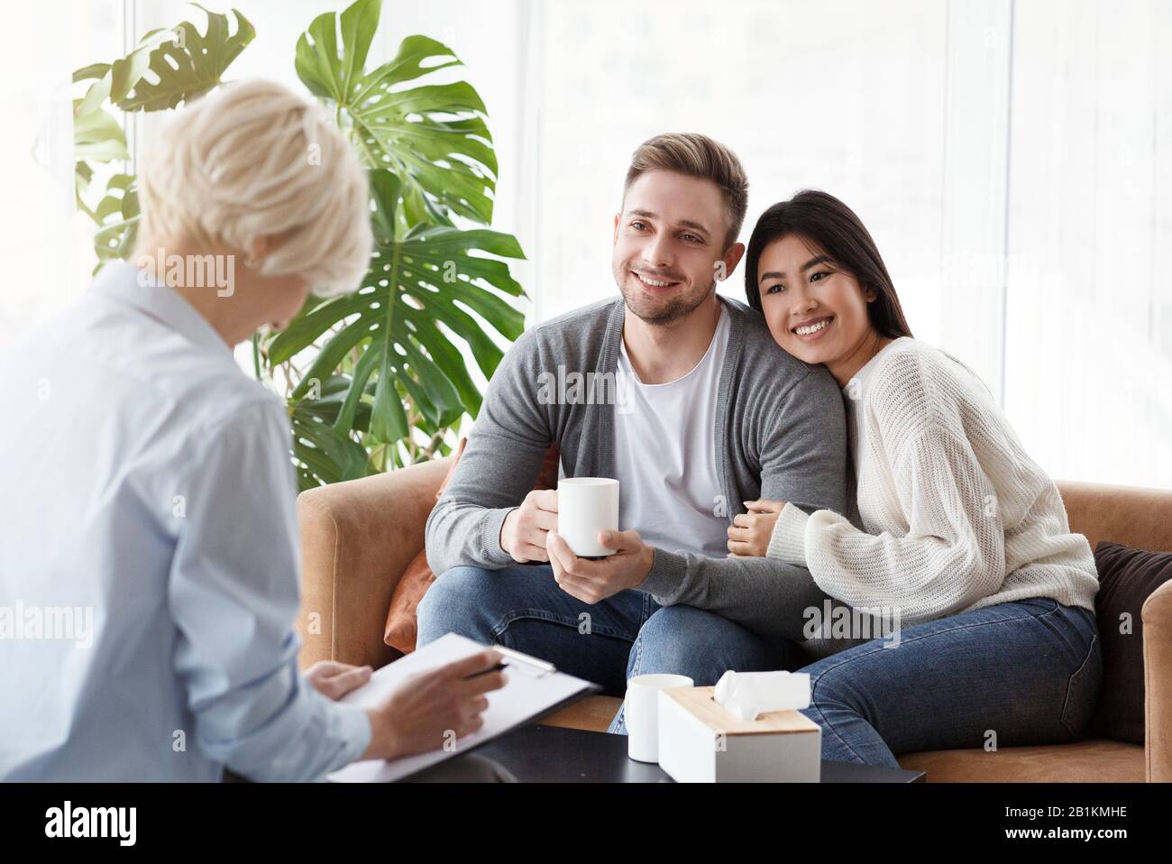 Fröhliches Junges Paar Im Gespräch Mit Familienpsychologen Im Büro Stockfoto