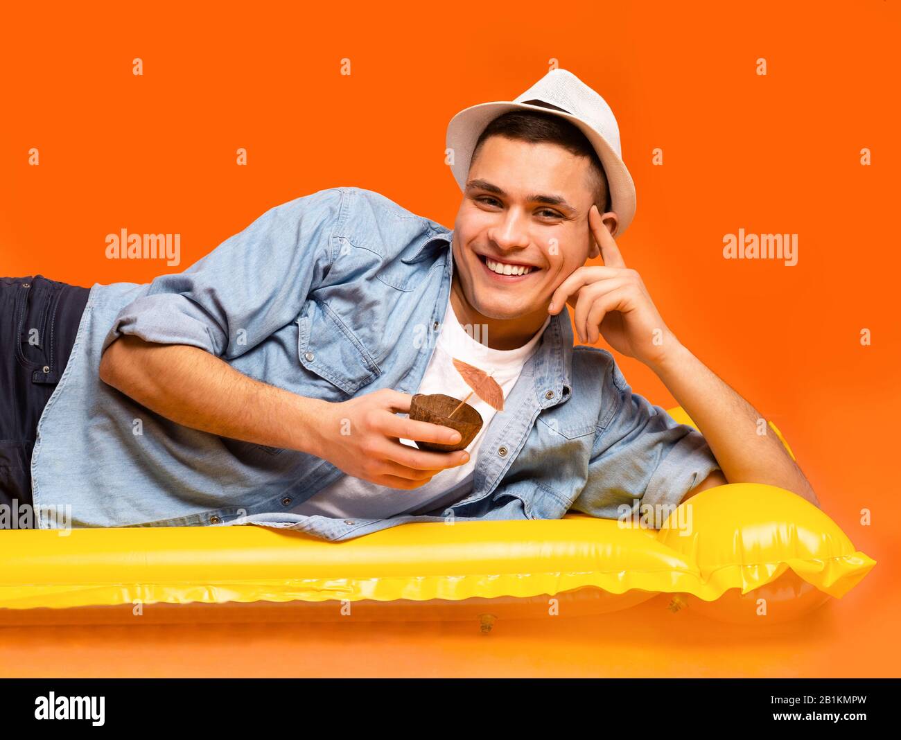 Portrait von Kerl Touristen, die auf aufblasbarer Matratze ruhen, Trinkcocktail Stockfoto