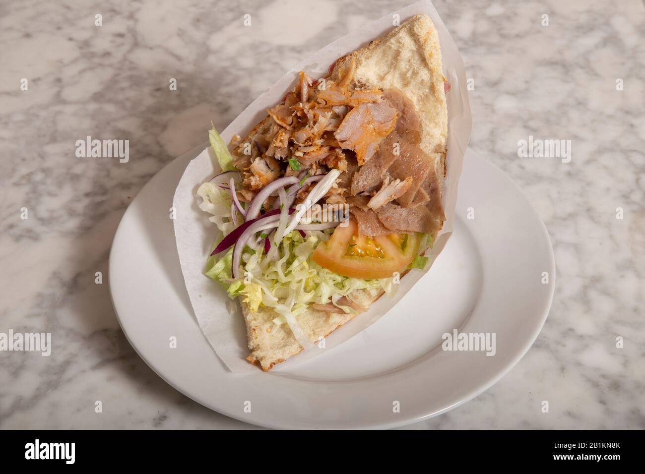 Donner Kebab serviert auf dem Teller auf dem Marmortisch. Typische Speisen aus Istanbul Stockfotografie