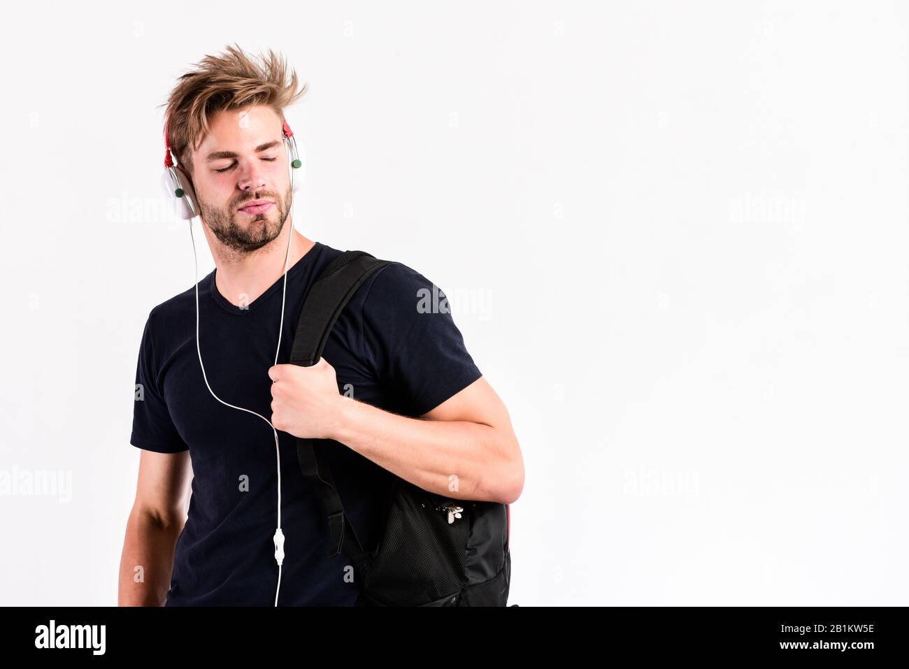 Musikanwendung herunterladen. Modernes Konzept für Menschen. Jugendmusik schmecken. Student gutaussehender Kerl, der Musik hört. Mann angepriesen Frisur tragen Kunststoff-Ohrhörer Gadget. Genießen Sie Musik überall. Stockfoto