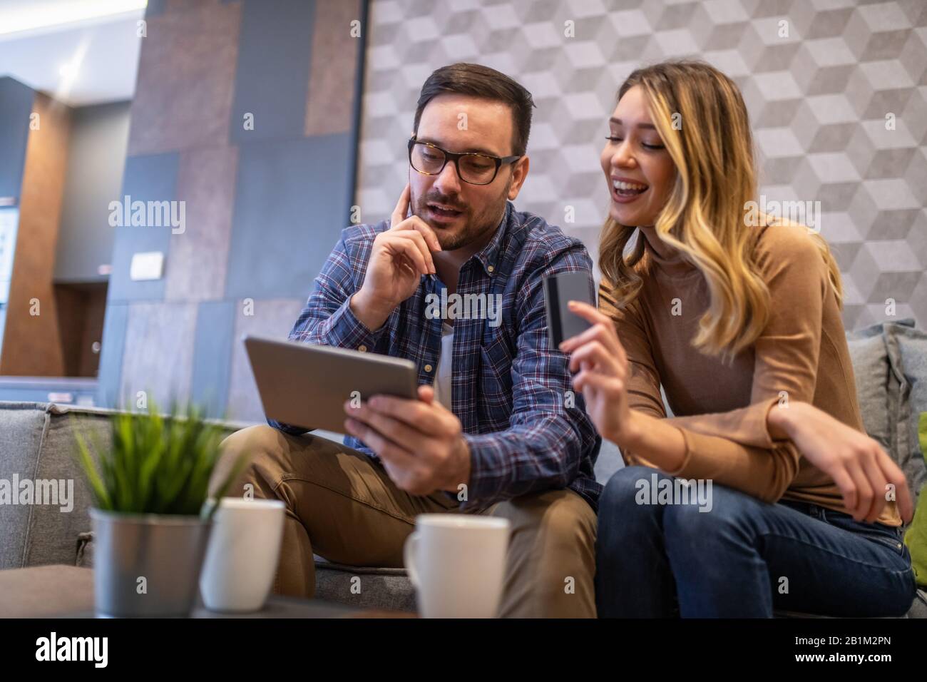 Junge Paare mit Tablet zu Hause. Sie surfen im Internet mit Tablet.People und Technologiekonzept. Stockfoto