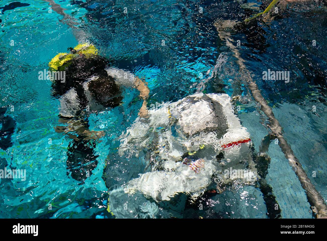 Mit einer Sicherheitstaucherin an ihrer Seite schwimmt die Veteranen-Astronautin Anne C. McClain im Neutral Buoyancy Lab der NASA in Houston, während sie sich einem neutralen Auftriebstraining unterzieht. Der 6,2 Millionen Liter fassende Pool enthält eine Verspottung der Internationalen Raumstation (ISS). Stockfoto