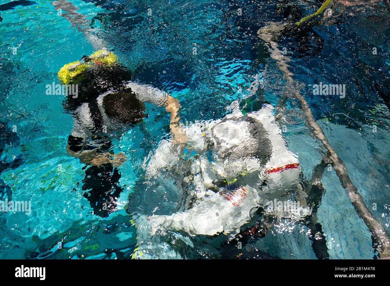 Mit einer Sicherheitstaucherin an ihrer Seite schwimmt die Veteranen-Astronautin Anne C. McClain im Neutral Buoyancy Lab der NASA in Houston, während sie sich einem neutralen Auftriebstraining unterzieht. Der 6,2 Millionen Liter fassende Pool enthält eine Verspottung der Internationalen Raumstation (ISS). Stockfoto