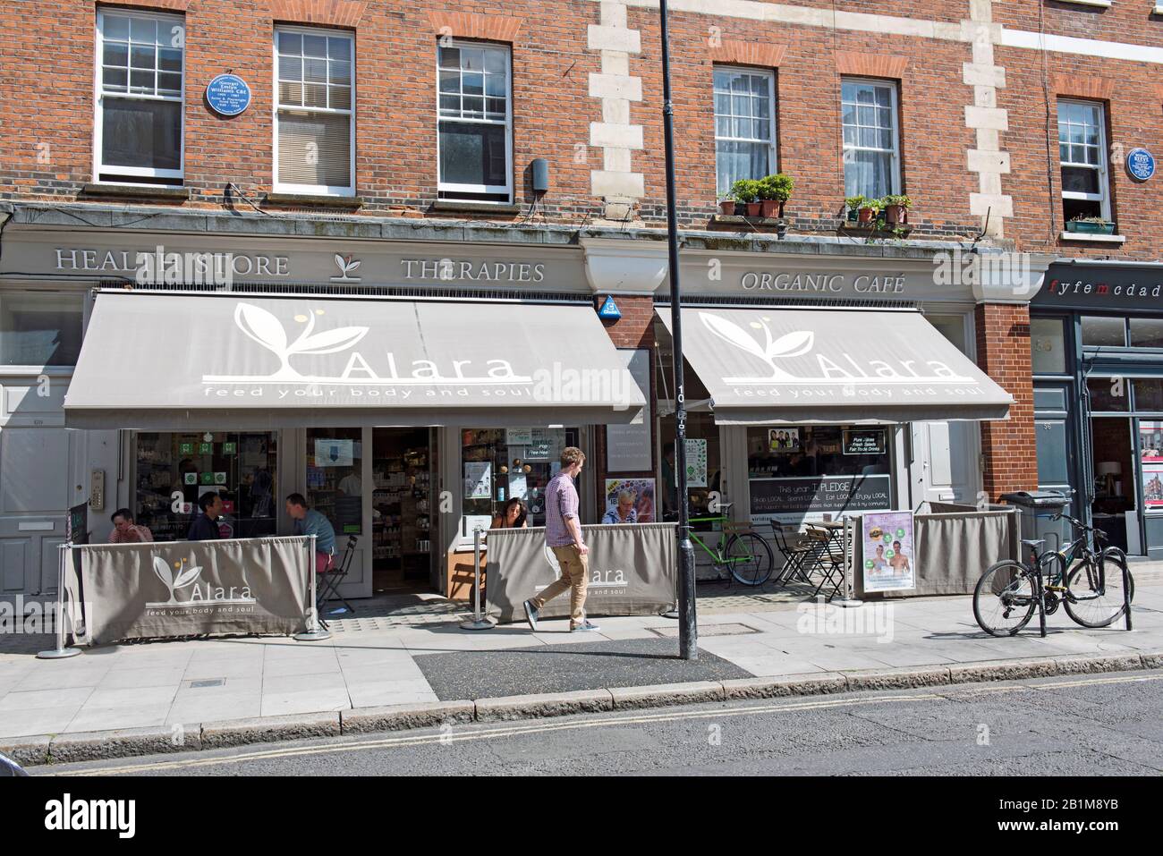 Alara Health Store und Organic Café mit Leuten, die draußen essen, Marchmont Street, Bloomsbury, London Stockfoto