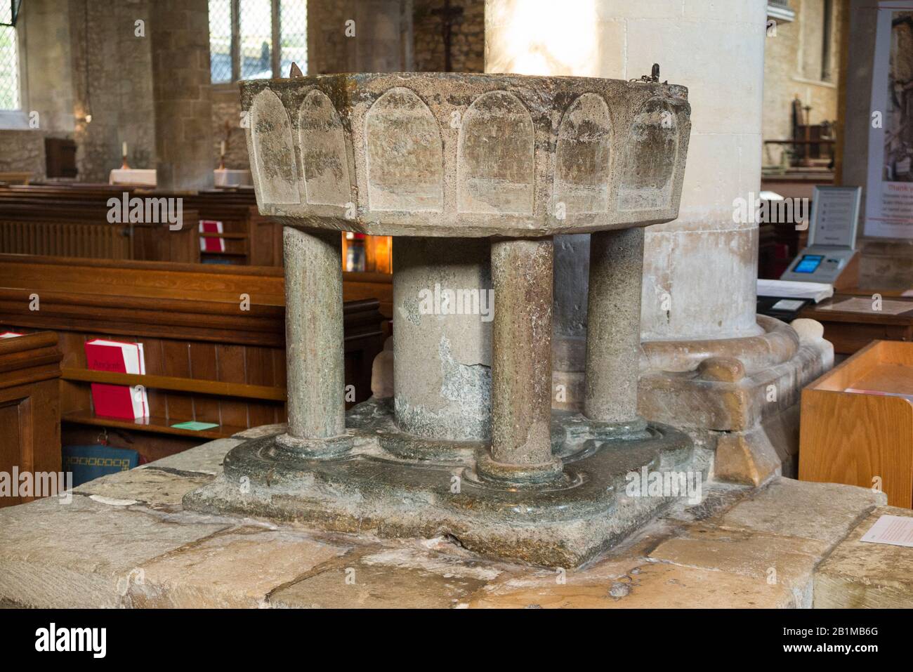 Achteckiges, aus Purbeck-Marmor geschnitztes, steinernes, spätnormannisches Taufbecken aus dem 12. Jahrhundert im Inneren der Kirche Bosham Holy Trinity. Bosham, West Sussex. GROSSBRITANNIEN. (114) Stockfoto