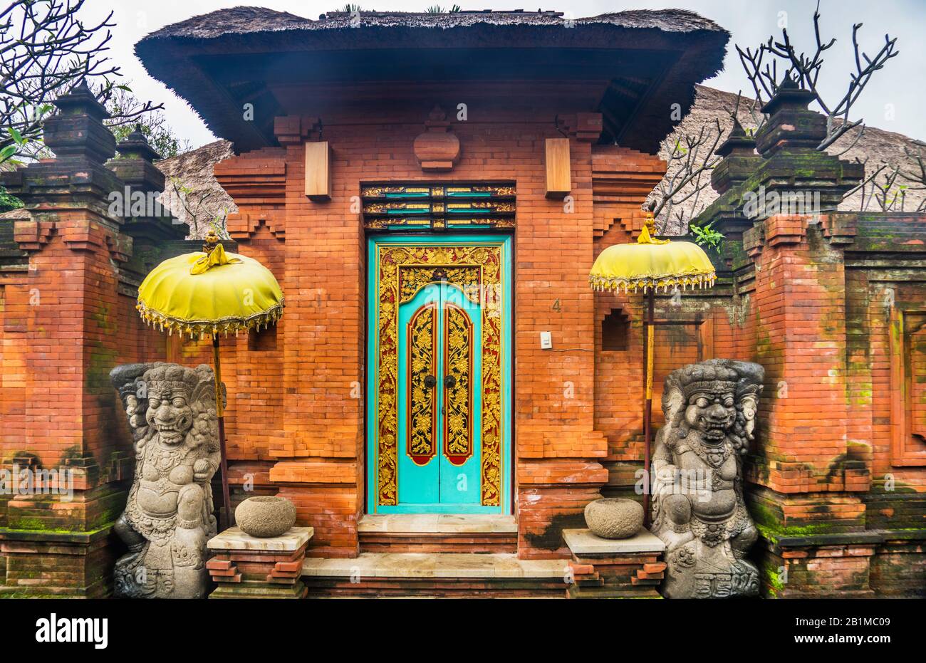 Indonesien, Bali, Sanur, traditioneller Eingang zum ummauerten Gehäuse einer balinesischen Residenz, flankiert von Zwillings-Dvarapalas-Wächterskulpturen Stockfoto