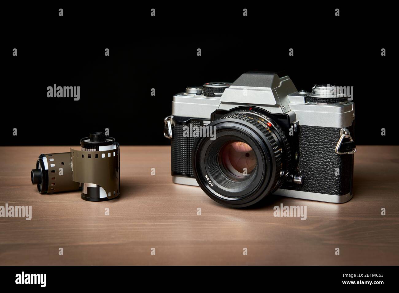 Klassische analoge 35-mm-Kamera und Filmrollen Vintage auf Holztisch Stockfoto