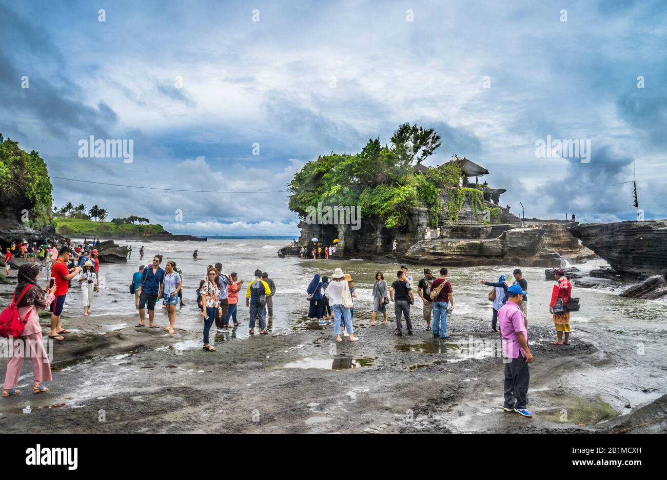 Besucher und Pilger in Tanah Lot, einer Felsformation vor der indonesischen Insel Bali, wo sich ein alter hinduistischer Pilgertempel Pura Tanah Lot, Bal, befindet Stockfoto