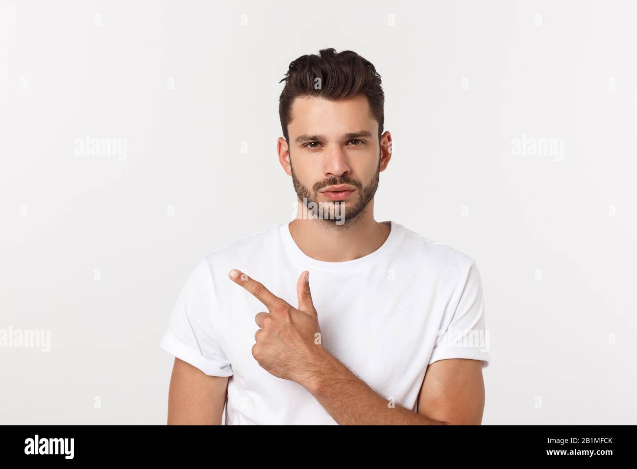 Nahaufnahme des enttäuschten gestressten bärtigen jungen Mannes im Hemd über weißem Hintergrund. Stockfoto