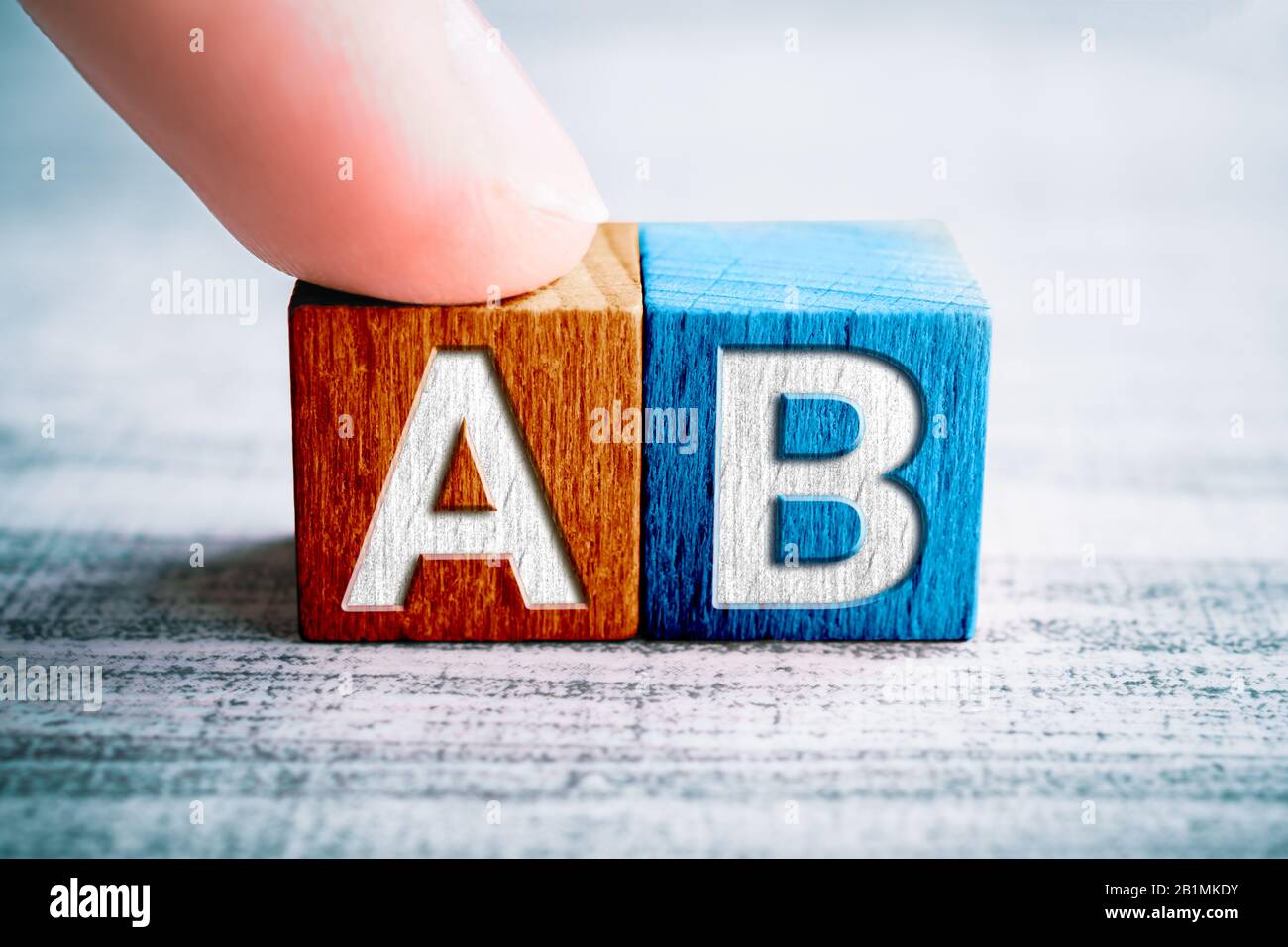 Wahl A und B auf Holzblöcken auf EINEM Tisch berührt EIN Finger Block A Stockfoto