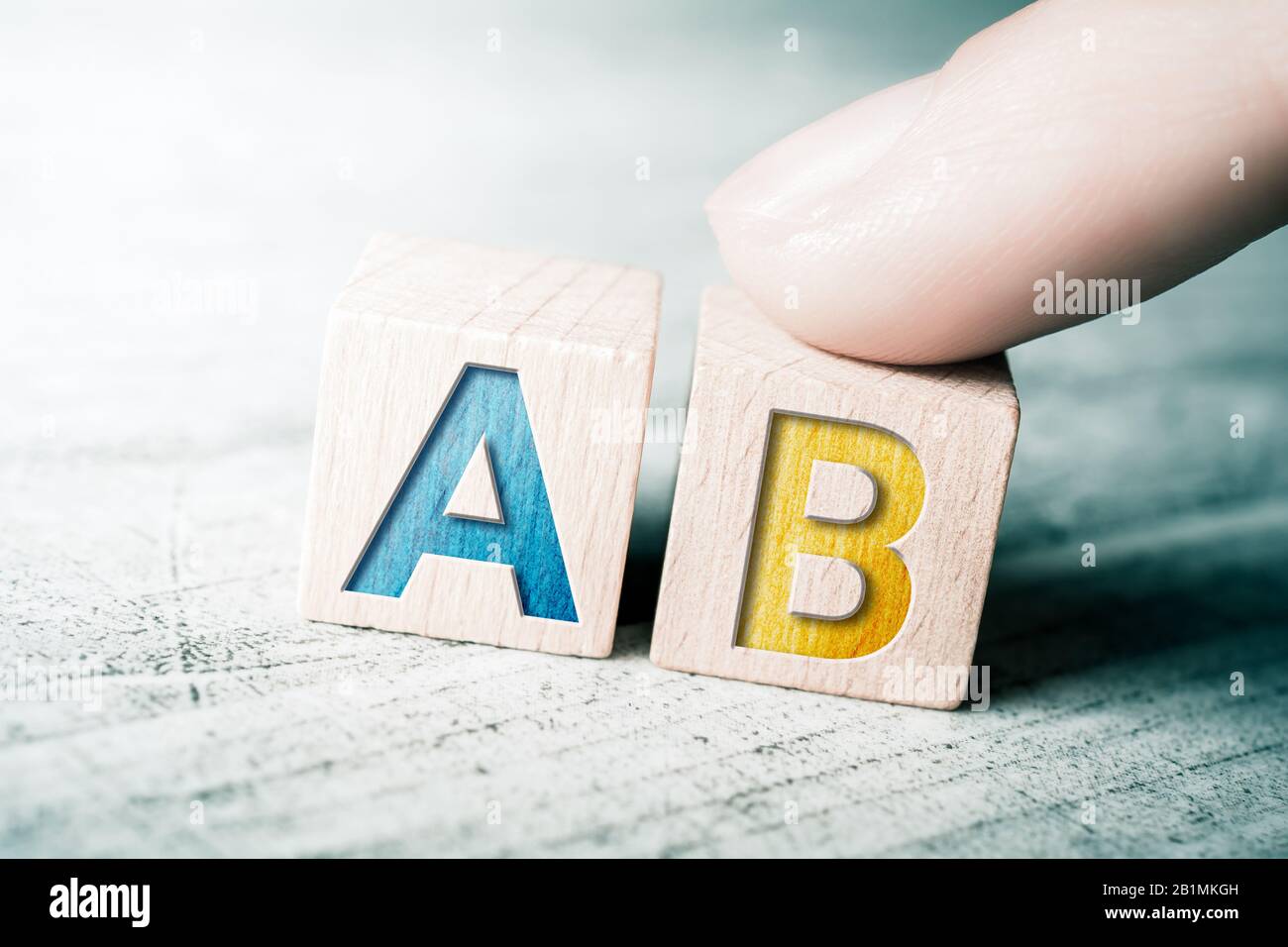 Chance A und B auf Holzblöcken auf EINEM Tisch berührt EIN Finger Block A Stockfoto