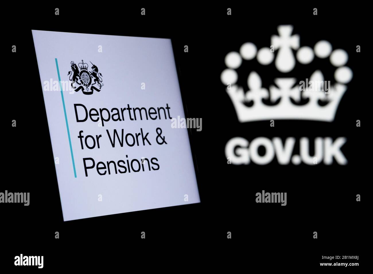 Das Logo des britischen Ministeriums für Arbeit und Renten leuchtet auf dem Smartphone-Bildschirm und das Logo von gov.uk auf dem verschwommenen dunklen Hintergrund. Konzeptfoto. Stockfoto
