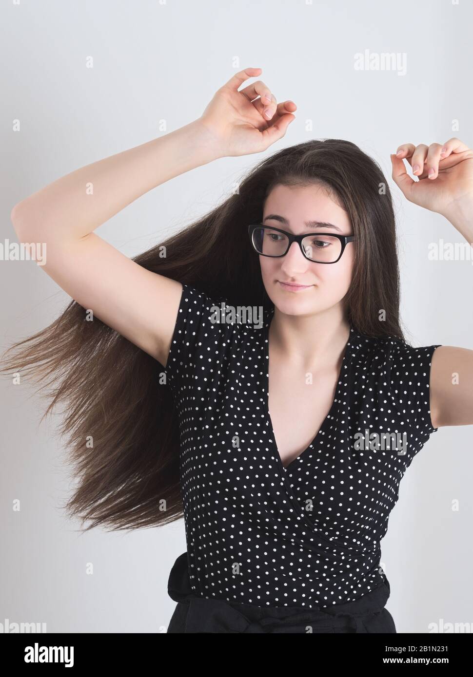 Porträt eines tanzenden Langhaarigen Brunette Teen Girl mit Händen in der Luft Stockfoto