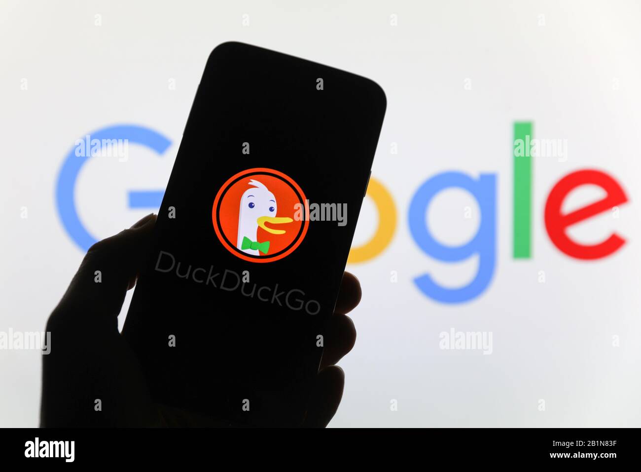 Ente Duck Go Websuchmaschine Firmenlogo auf dem Smartphone-Bildschirm mit im Hintergrund verschwommenem Google-Logo angezeigt Stockfoto