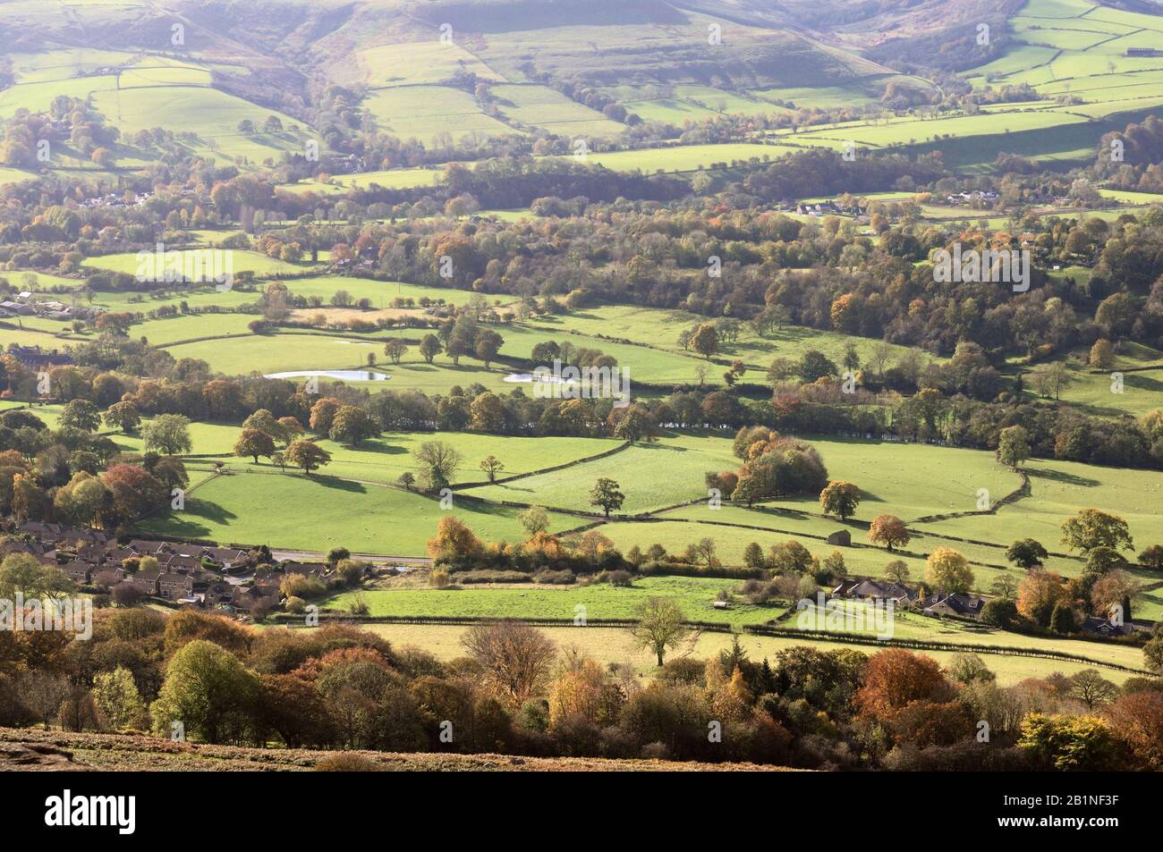 Sonnenschein über grünen Feldern und Herbstbäumen in Hope Valley, Peak District National Park, Derbyshire, England, Großbritannien Stockfoto