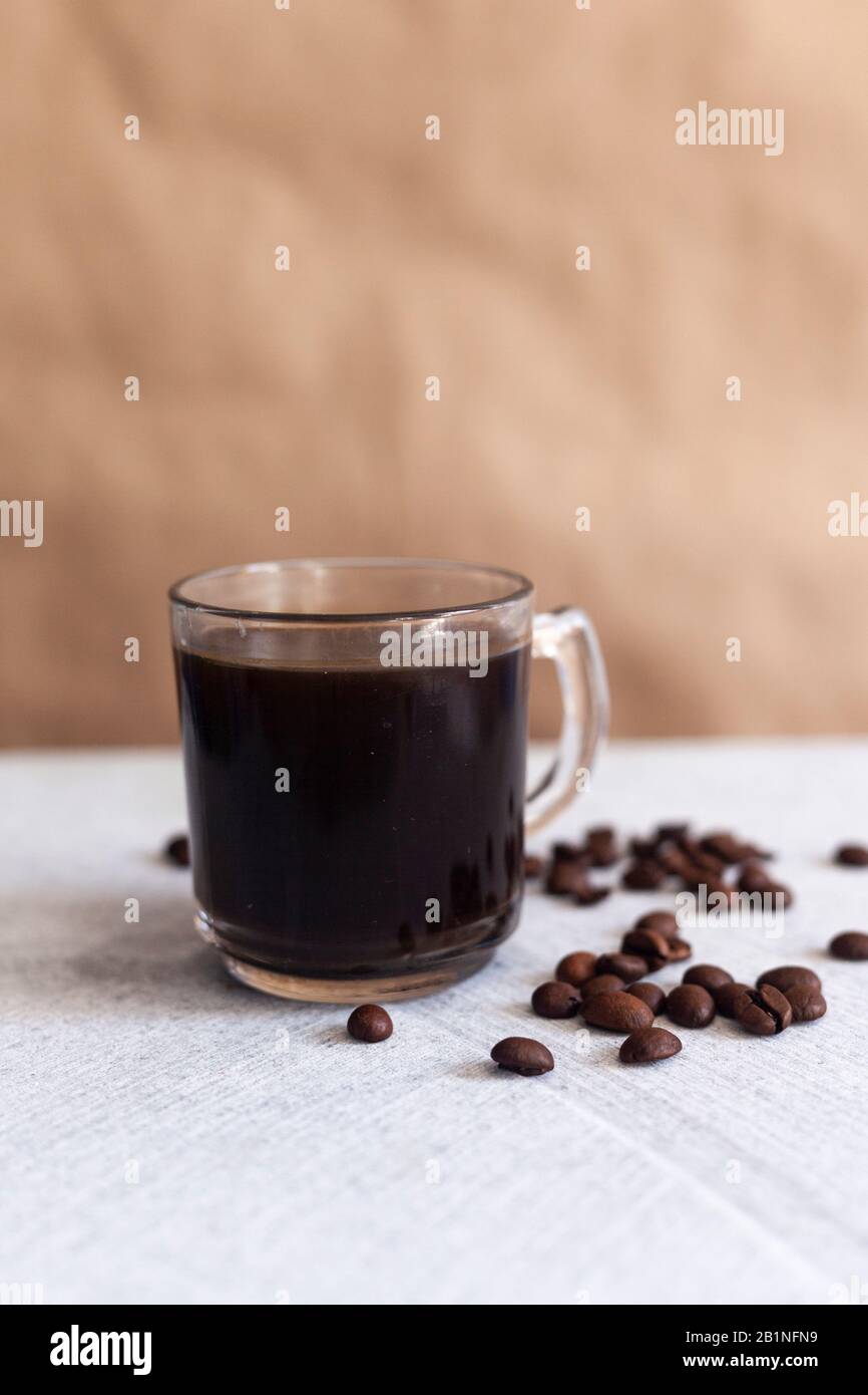 Eine Tasse schwarzen Kaffee und Bohnen auf Marmorgrund Stockfoto