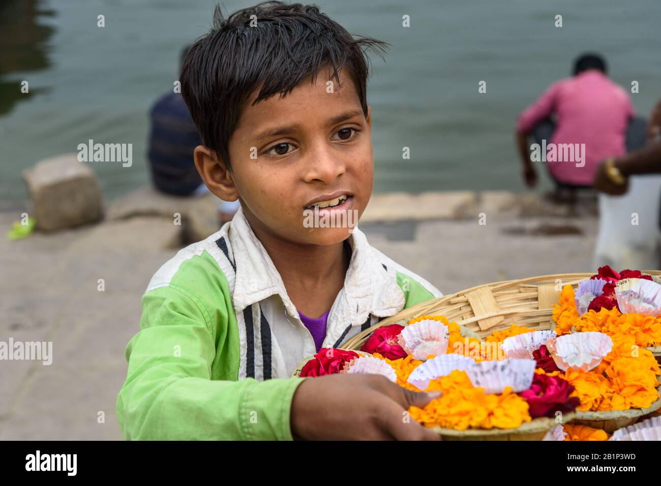 Der indische Junge bietet Kerzen mit Blumen für die gebeten auf dem Fluss Ganga auf Ghats an. Varanasi. Indien Stockfoto