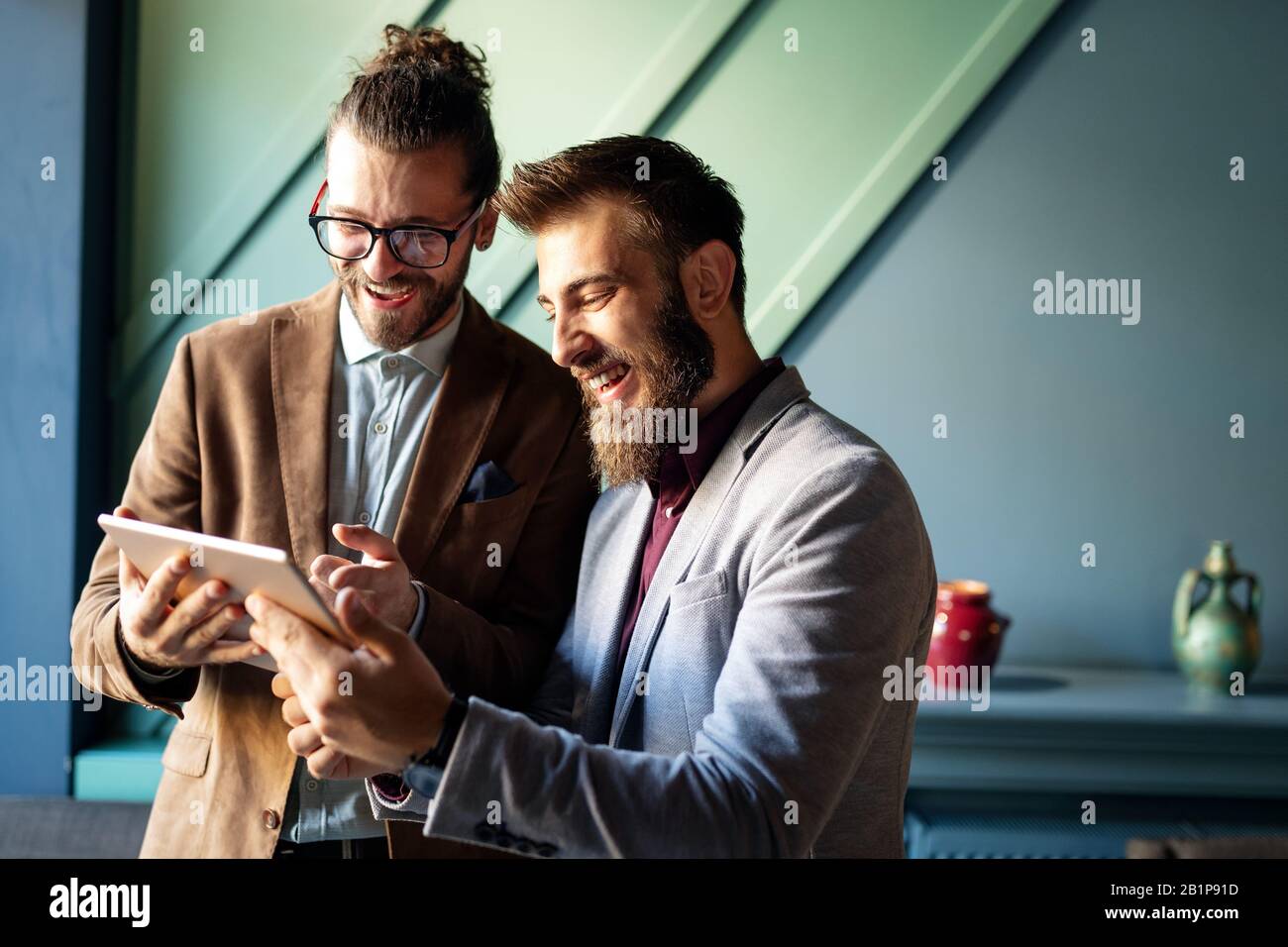 Portrait glücklicher Geschäftsleute, die digitale Geräte bei der Besprechung nutzen Stockfoto