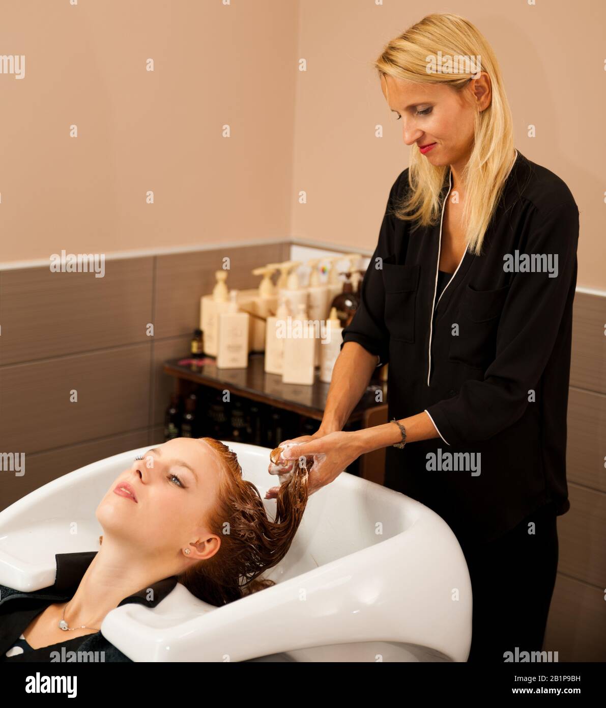 Friseur am Arbeitsplatz - Friseur waschen Haare an den Kunden zuvor Frisur Stockfoto