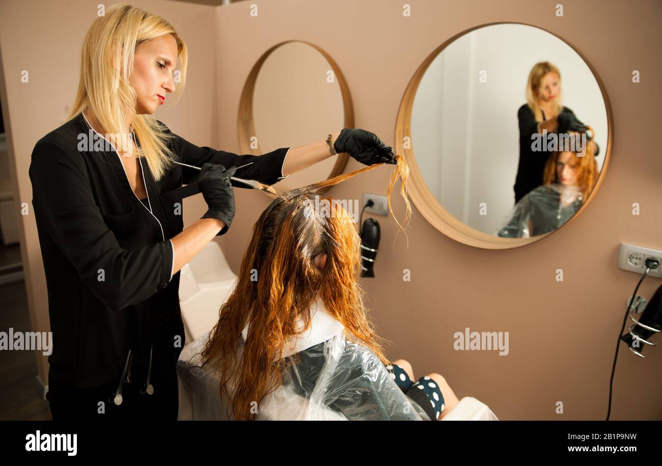 Haarstylisten bei der Arbeit - Friseursalon, der Farbe auf einsames Haar anwendet Stockfoto