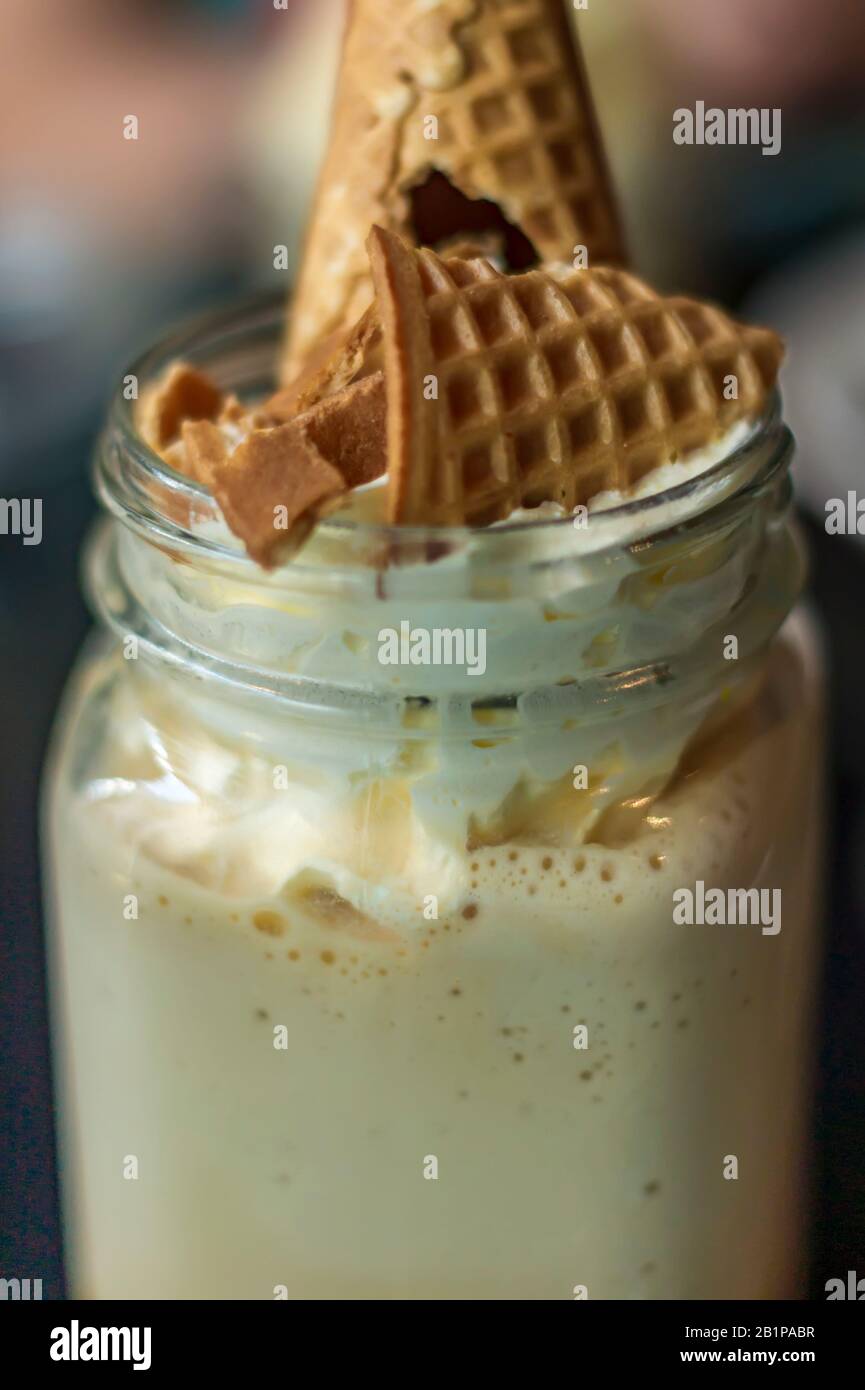 Nahaufnahme von kaltem Kaffee mit Schlagsahne und Waffelkonus Stockfoto