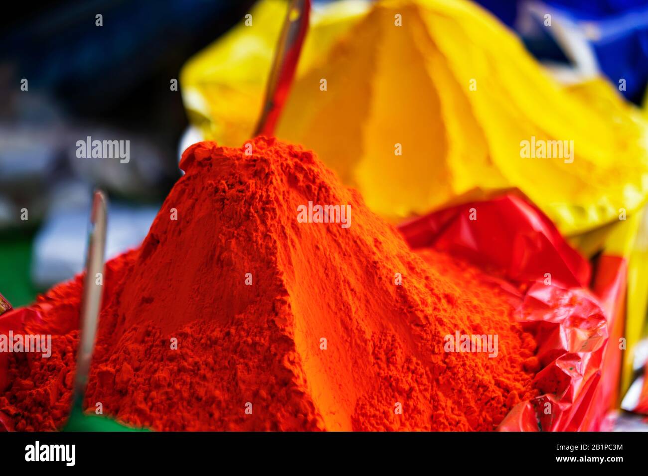 Orangefarbenes Holi-Pulver. Nahaufnahme von orangefarbenem, gelbem Holi-Pulver auf einem lokalen Markt für indisches Holi-Festival mit Kopierraum. Konzept für Backgroun Stockfoto