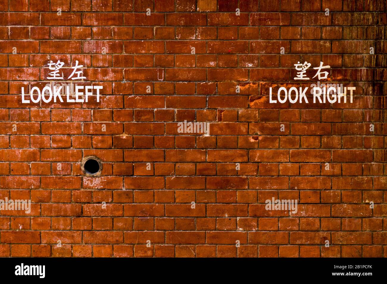 Abstrakte braune Ziegelmuster mit Chinesisch und Englisch Bemalten Wörtern: "LOOK LEFT LOOK RIGHT" als Hintergrund oder Textur Stockfoto