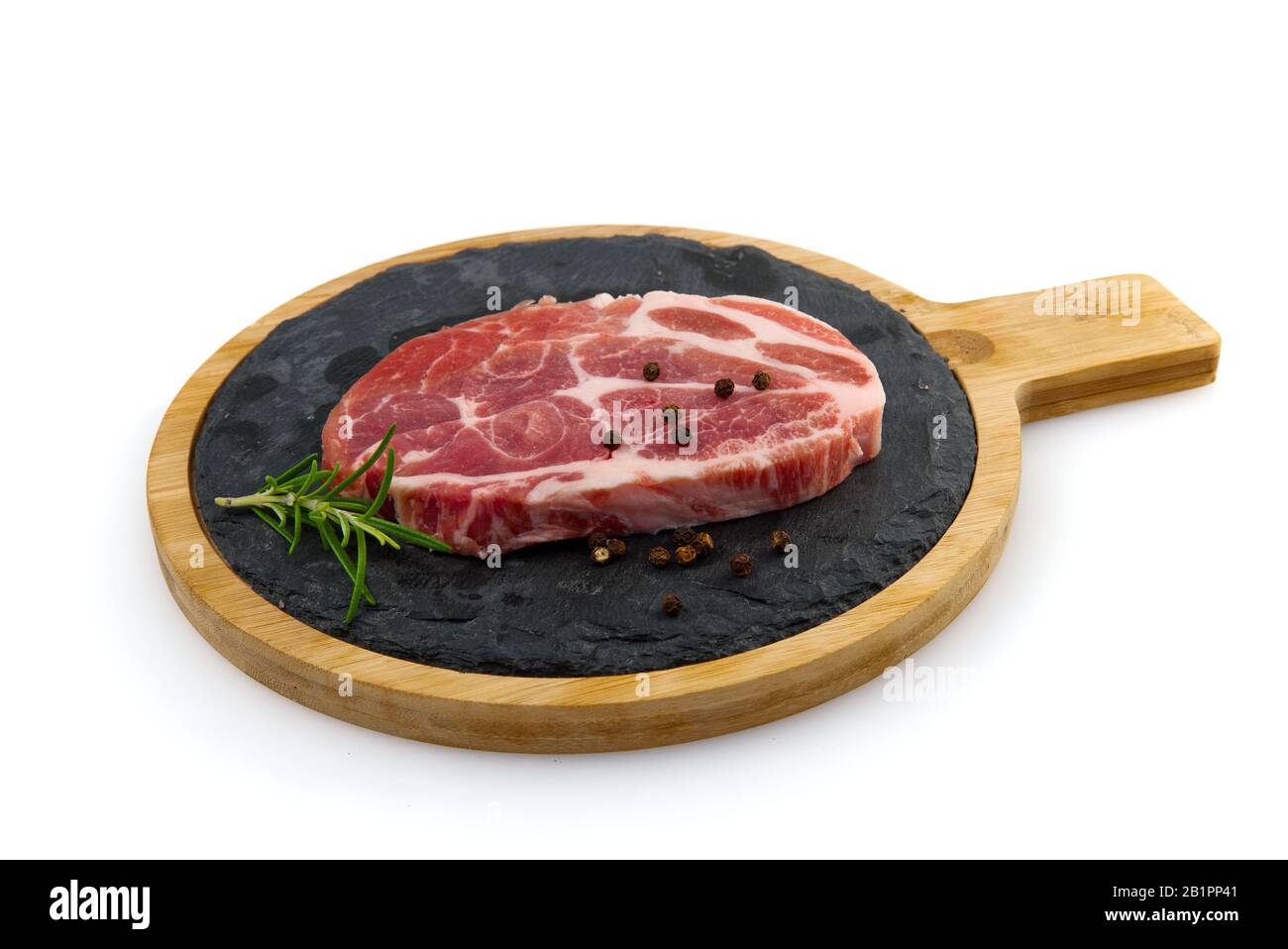 Single Raw Schweinefleisch slic auf schwarzem Steinteller, isoliert auf Weiß. Stockfoto