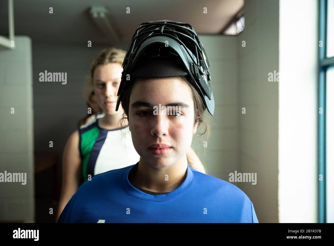 Hockeyspielerin mit Blick auf die Kamera Stockfoto