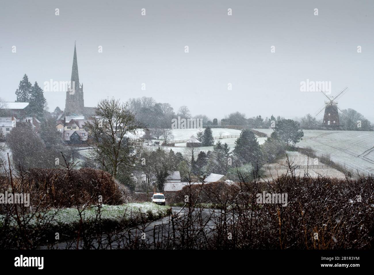 Thaxted, Großbritannien. Februar 2020. Wetter in Großbritannien. Thaxted Essex England bedeckt mit Schnee 27. Februar 2020 Thaxted Church aus dem 14. Jahrhundert und John Webbs Windmaill aus dem Jahr 2007, die durch einen leichten Schneebefall, den ersten in diesem Winter, von Cutlers Green Thaxted in North Essex gesehen wurde, gesehen wurde. Foto Credit: Brian HARRIS/Alamy Live News Stockfoto