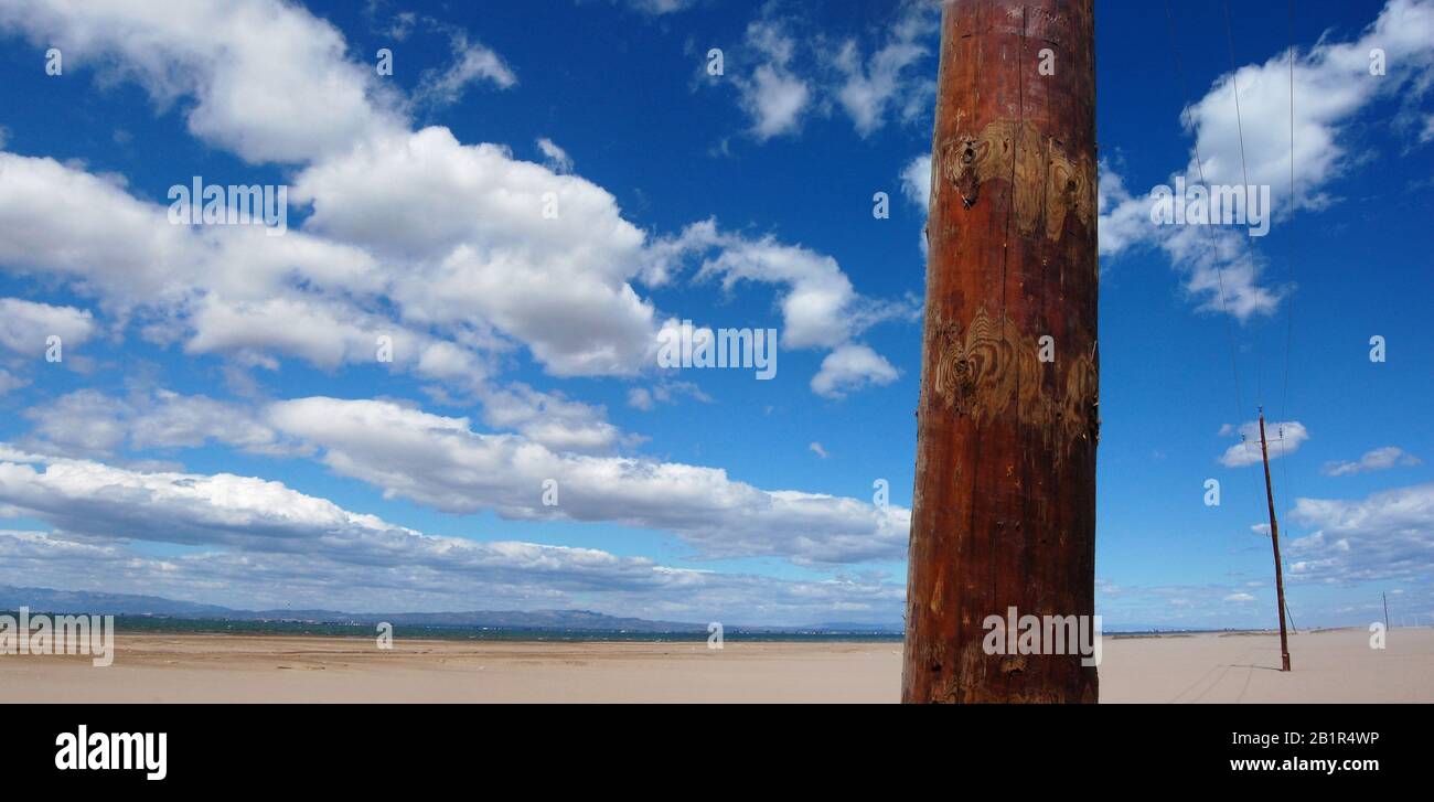 Panoramablick auf einen Holzstrompolster am Strand mit trübem blauem Himmel Stockfoto