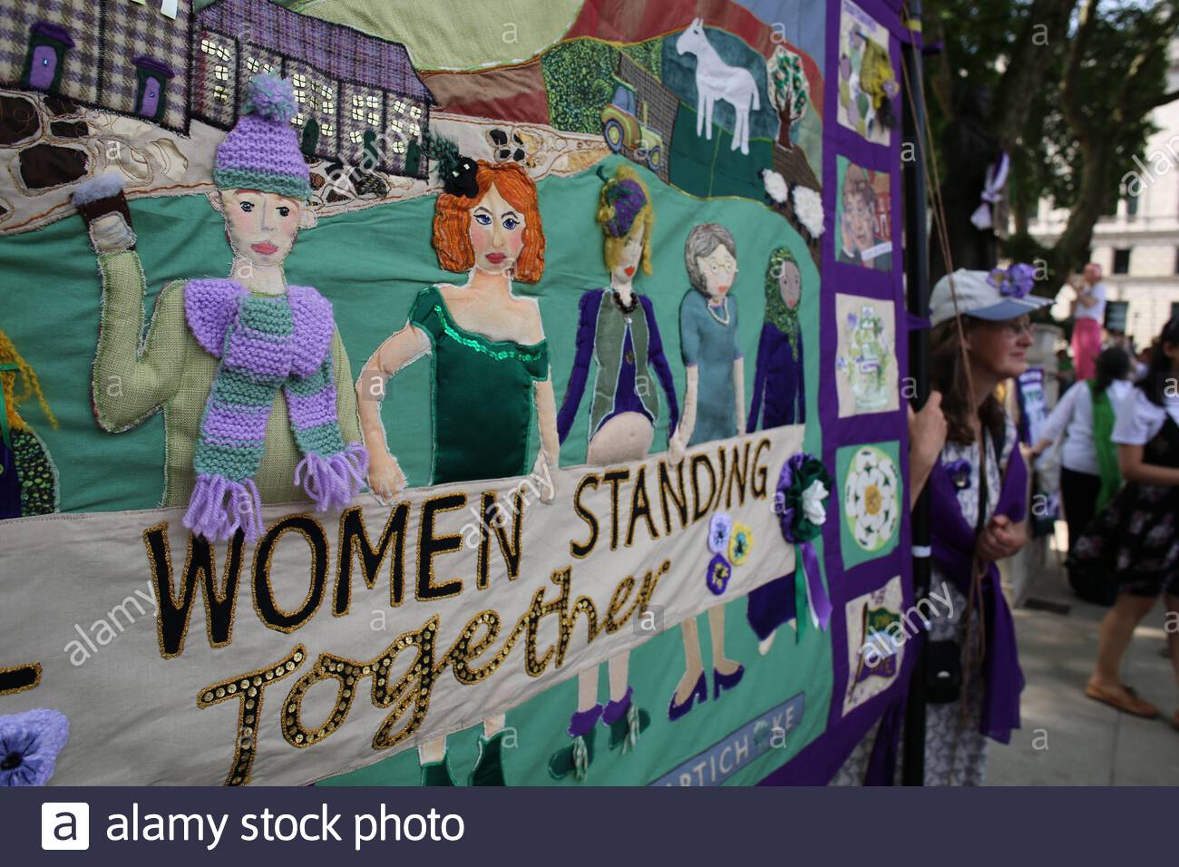Ein Banner mit den Worten, Die Frauen in Wwestminster zusammenstehen, die von Frauen gemacht wurden, die an der 100-Jahre-Wahlparade teilnahmen. Stockfoto