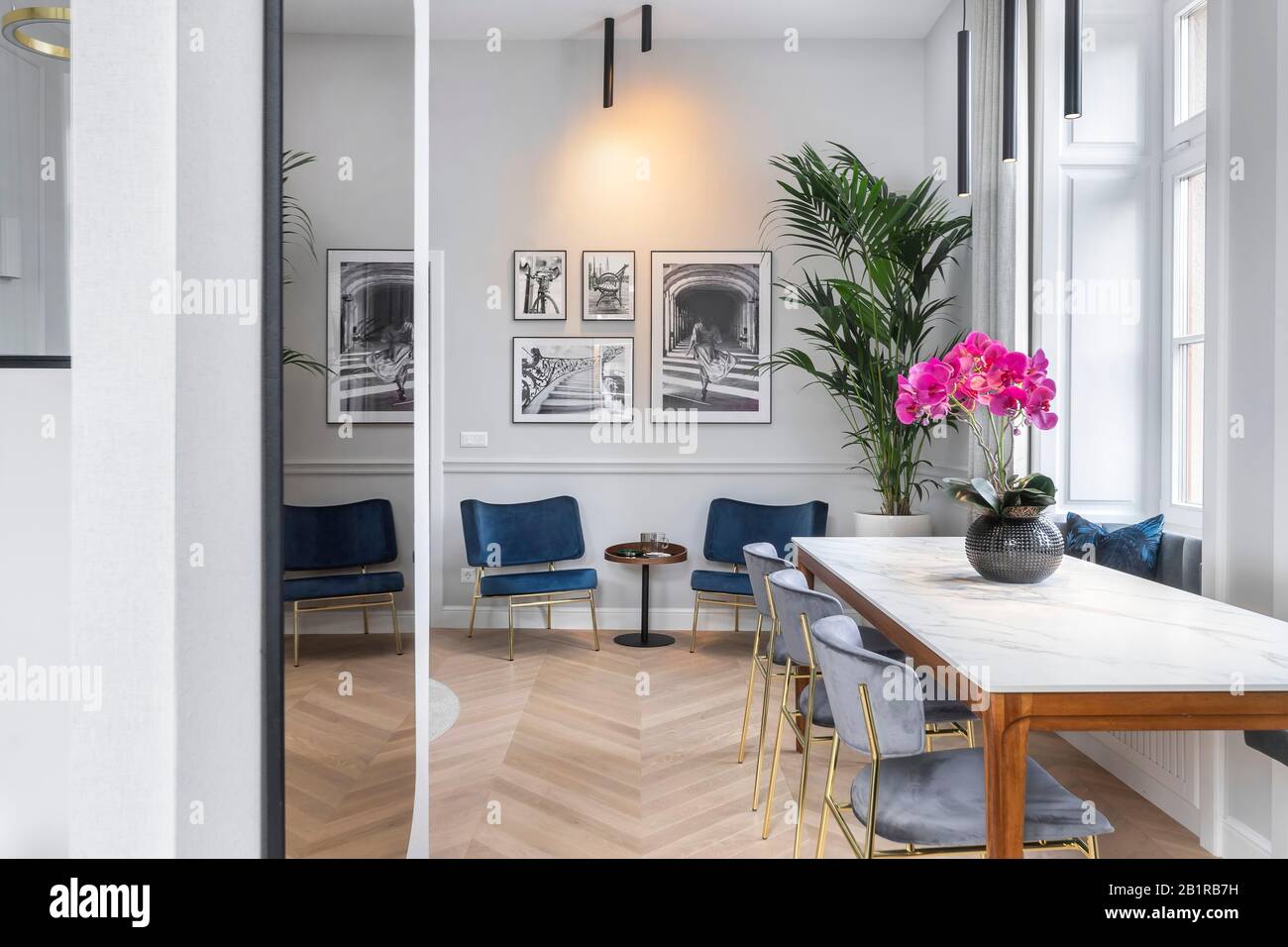 Budapest, Ungarn - 28. November 2019: Luxuriöser stilvoller Ess- und Sitzbereich mit Schwarz-Weiß-Bildern in einer hellen Wohnung. Stockfoto