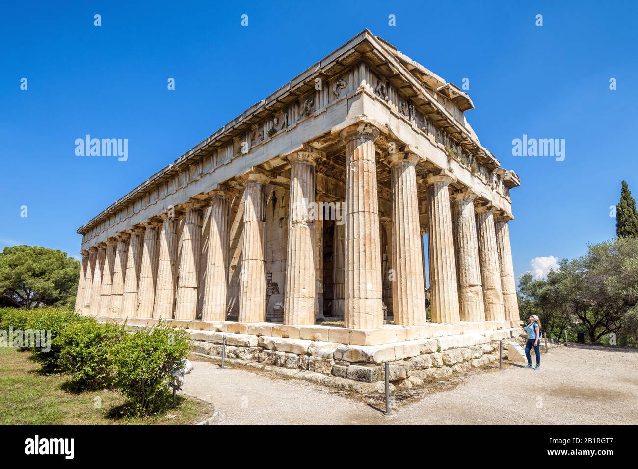 Tempel von Hephaestus im Sommer, Athen, Griechenland. Dieses alte griechische Gebäude ist eines der Hauptmerkmale Athens. Junge Frau Touristin blickt auf das f Stockfoto