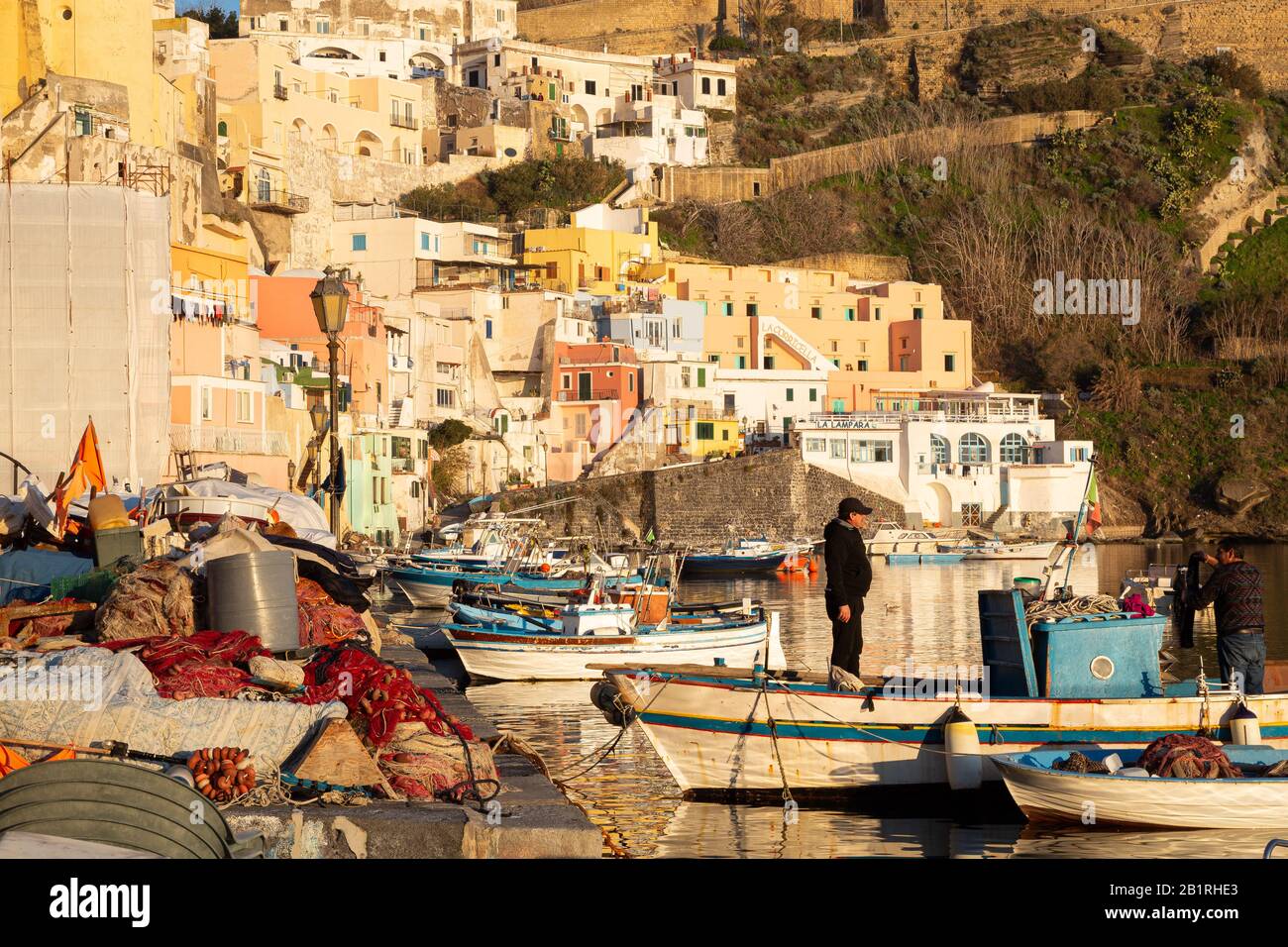 Procida, ITALIEN - 3. JANUAR 2020 - Blick auf die Corricella-Bucht im Sonnenuntergang, einem romantischen Fischerdorf in Procida, Italien Stockfoto