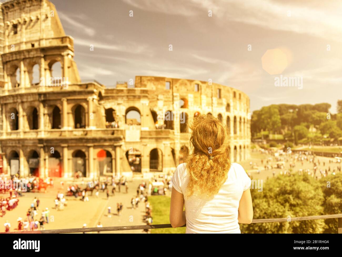 Die Touristin schaut auf das Kolosseum in Rom, Italien. Das Kolosseum ist ein wichtiges Denkmal der Antike und gehört zu den wichtigsten Touristenattraktionen Stockfoto