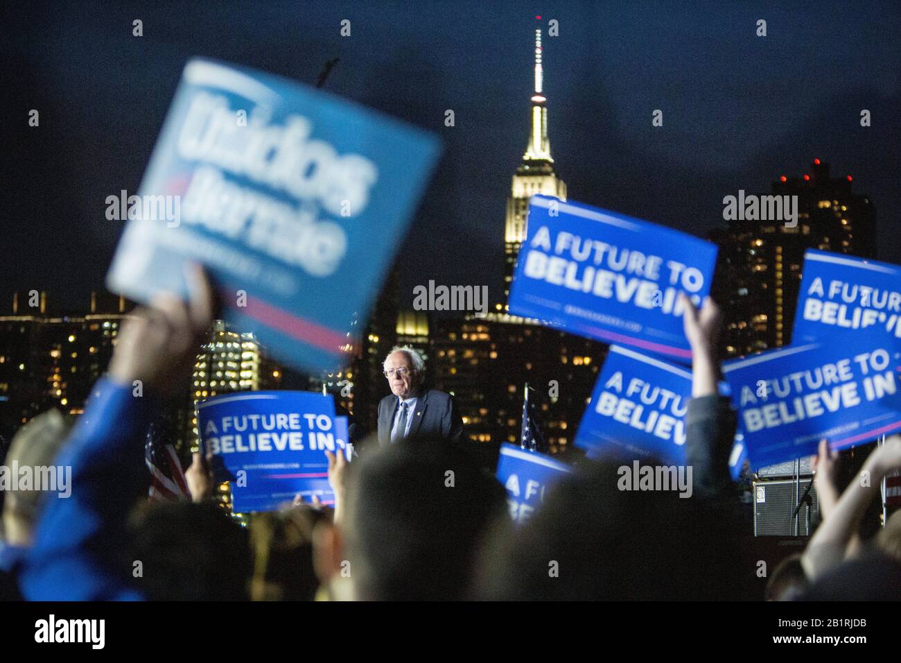 Am Vorabend vor den Wahlen zum Staat New York 2016 hält der vom Präsidenten hoffnungsvolle Senator Bernie Sanders (D-Vt) eine letzte Kundgebung im Hunters Point South Park in Queens ab. Sein Wahlspruch "A Future to Believe in" steht auf allen Plakaten und mit der Skyline von Manhattan als Kulisse mit dem Empire State Building deutlich zu sehen. Stockfoto